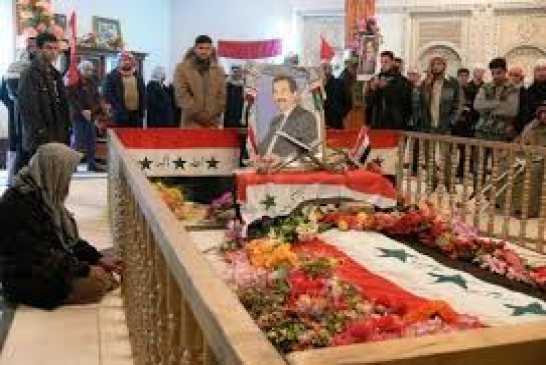 الشيعة يعبثون بقبر صدام حسين ويضعون أعلام لرموز شيعية